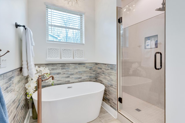 bathroom with tile walls and separate shower and tub