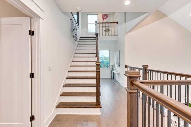 stairs featuring wood-type flooring and a wealth of natural light