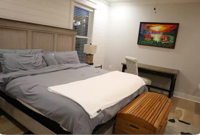 bedroom featuring wood-type flooring and ornamental molding