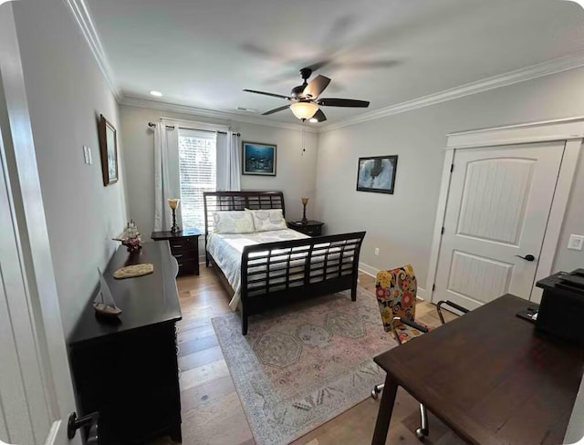 bedroom featuring ceiling fan, crown molding, and light hardwood / wood-style flooring