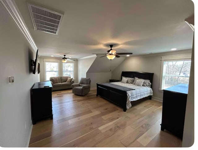 bedroom featuring hardwood / wood-style flooring, ceiling fan, ornamental molding, and vaulted ceiling