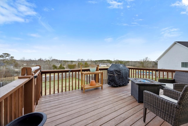 wooden terrace featuring grilling area and a fire pit