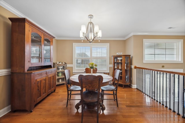 dining room featuring a chandelier, dark hardwood / wood-style flooring, and ornamental molding