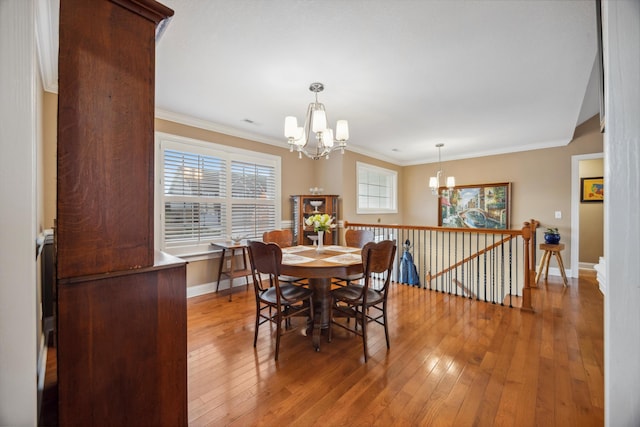 dining space featuring a chandelier, hardwood / wood-style flooring, and crown molding