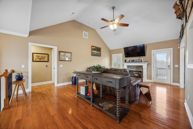 living room with hardwood / wood-style floors, ceiling fan, plenty of natural light, and a fireplace