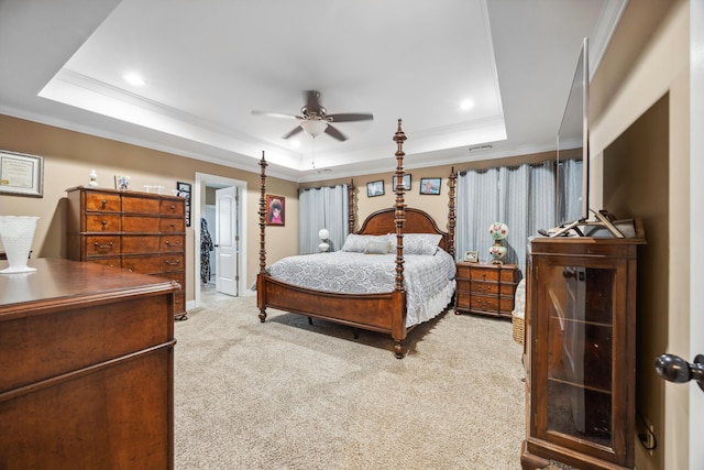 carpeted bedroom featuring a raised ceiling, crown molding, ceiling fan, and ensuite bathroom