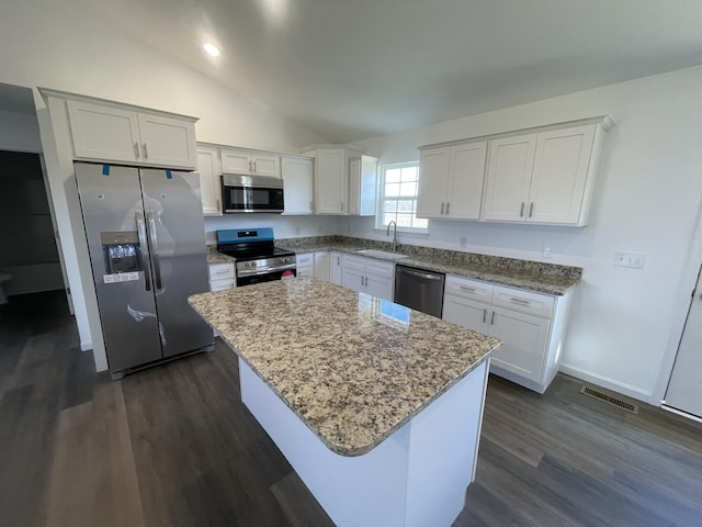 kitchen featuring white cabinets, appliances with stainless steel finishes, a center island, and sink