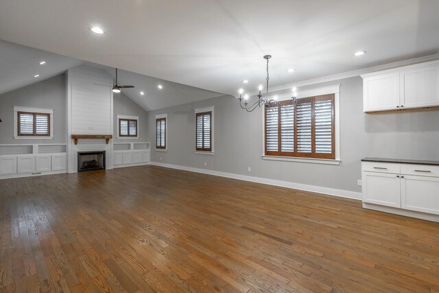 unfurnished living room featuring hardwood / wood-style floors, ceiling fan with notable chandelier, a large fireplace, and lofted ceiling