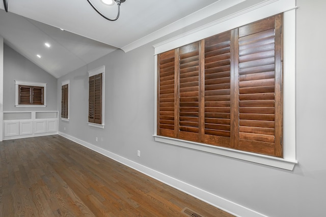 interior space with built in shelves, dark hardwood / wood-style floors, and vaulted ceiling