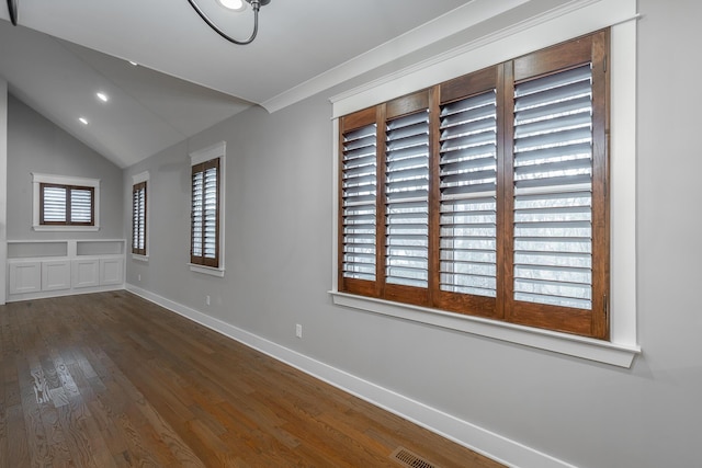 spare room featuring dark hardwood / wood-style floors and vaulted ceiling