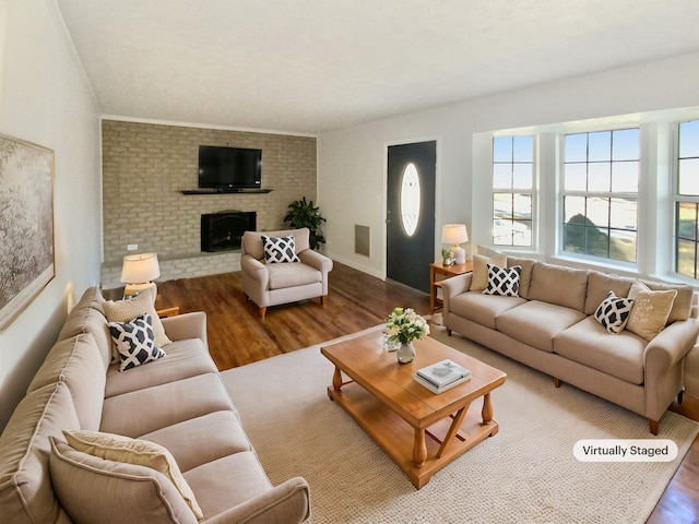 living room featuring hardwood / wood-style floors and a brick fireplace