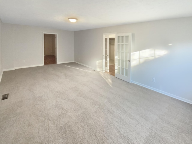 carpeted empty room featuring french doors