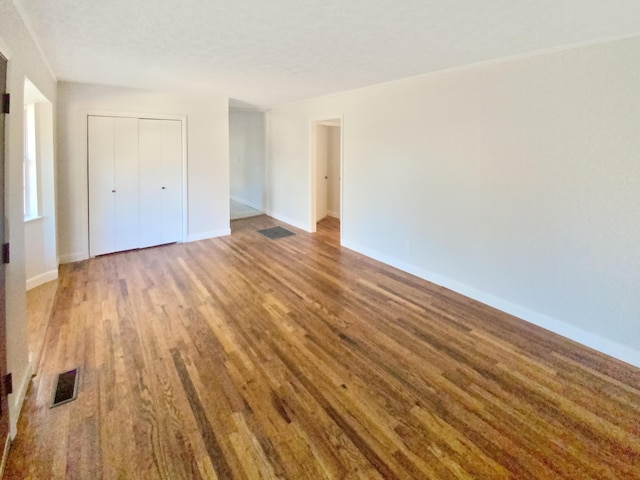 unfurnished bedroom featuring wood-type flooring and a closet