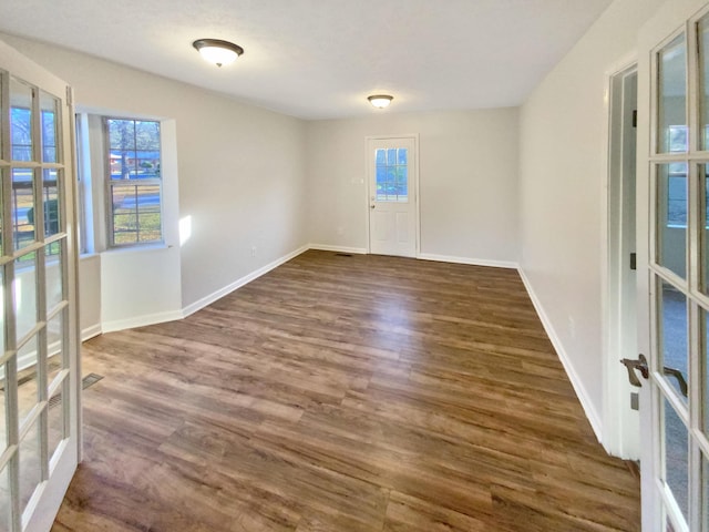 spare room featuring french doors and dark hardwood / wood-style floors