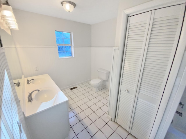 bathroom with tile patterned flooring, vanity, and toilet