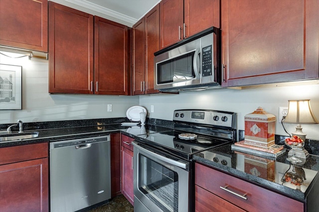 kitchen with crown molding, dark stone countertops, sink, and stainless steel appliances