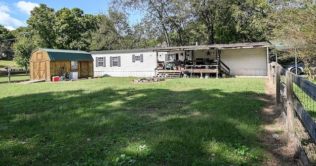 rear view of property with a shed, a deck, and a lawn