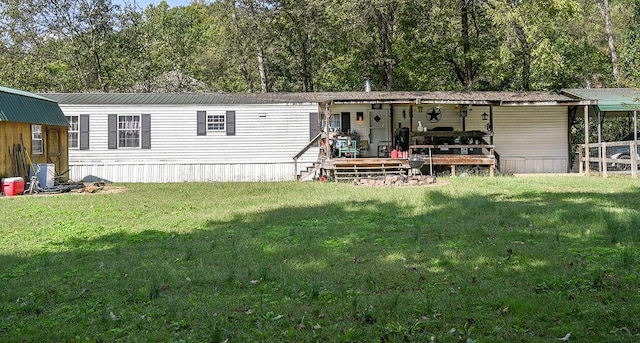 rear view of property featuring a wooden deck and a lawn