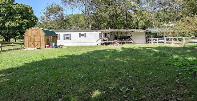 rear view of property with a yard and a storage shed