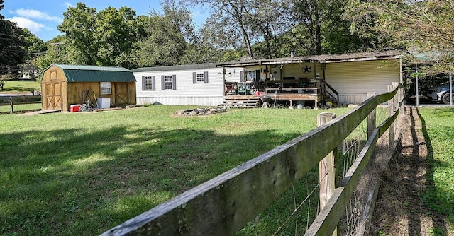 rear view of property featuring a storage shed and a yard