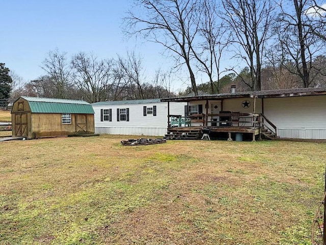 back of house with a wooden deck, a yard, and a shed