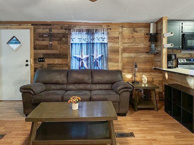 living room featuring wooden walls and light wood-type flooring