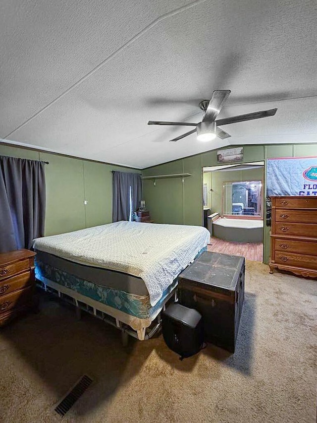 carpeted bedroom featuring vaulted ceiling, ceiling fan, and a textured ceiling