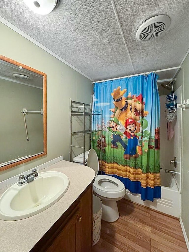 full bathroom featuring toilet, wood-type flooring, shower / tub combo, a textured ceiling, and vanity