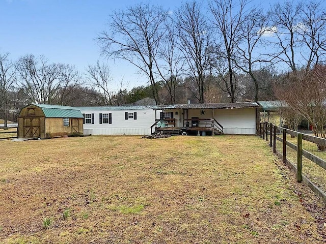 back of house featuring a storage shed and a yard