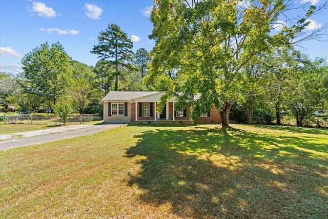 ranch-style home with covered porch and a front yard