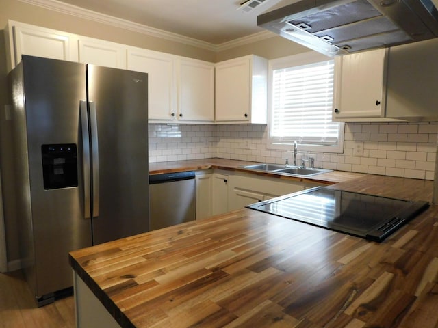 kitchen featuring white cabinets, stainless steel appliances, and wooden counters