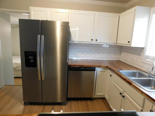 kitchen featuring butcher block counters, sink, white cabinets, and stainless steel appliances