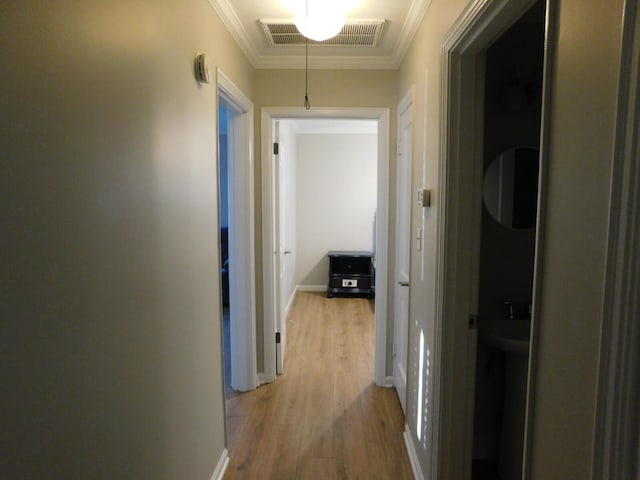 hall featuring crown molding and light wood-type flooring