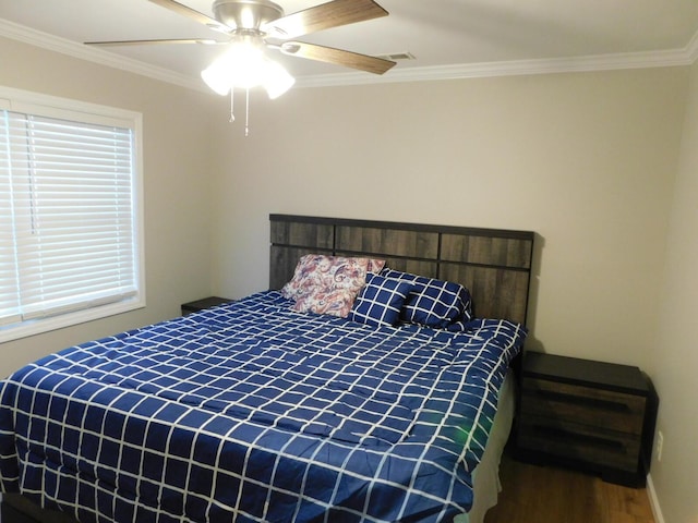 bedroom with multiple windows, ceiling fan, crown molding, and hardwood / wood-style flooring