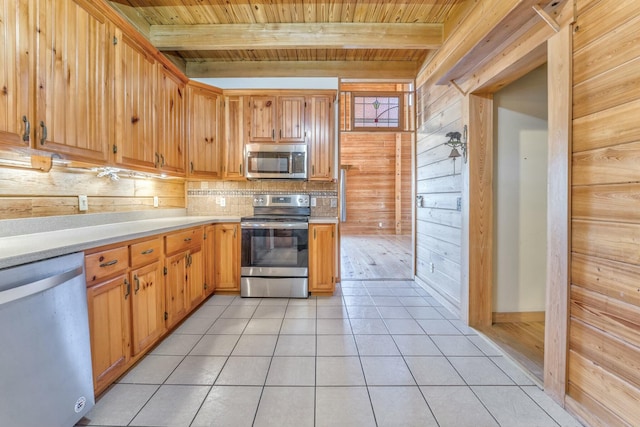 kitchen with stainless steel appliances, wooden ceiling, wood walls, and beamed ceiling