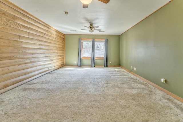 empty room featuring carpet floors, ceiling fan, and rustic walls