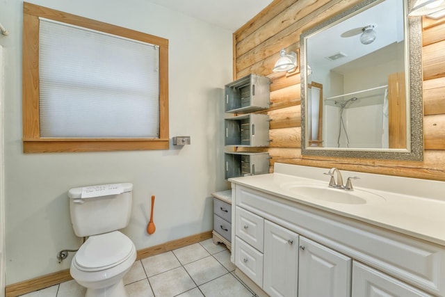 bathroom featuring toilet, a shower, wooden walls, tile patterned floors, and vanity