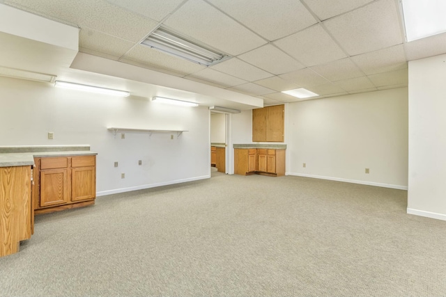 basement featuring a drop ceiling and light carpet