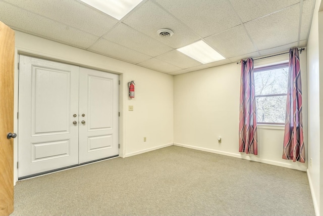 unfurnished room with a paneled ceiling and light colored carpet