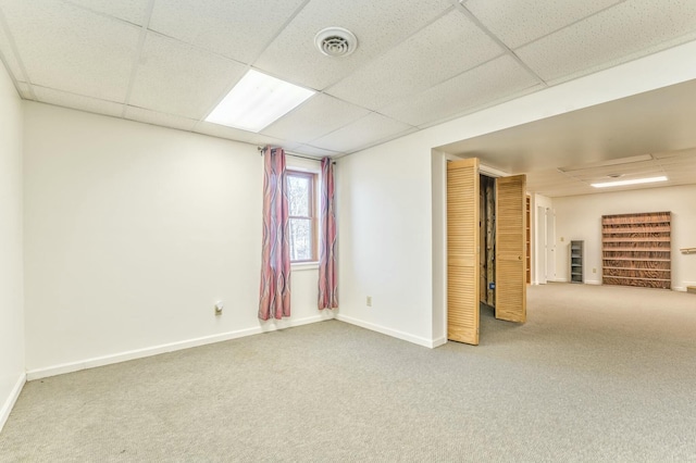 basement with a paneled ceiling and carpet flooring