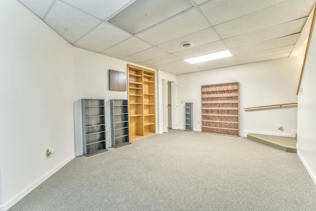 basement with a paneled ceiling and carpet floors