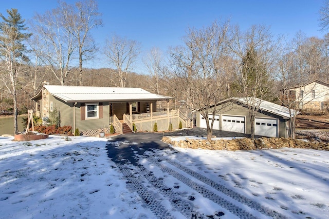 single story home with an outbuilding, a porch, and a garage