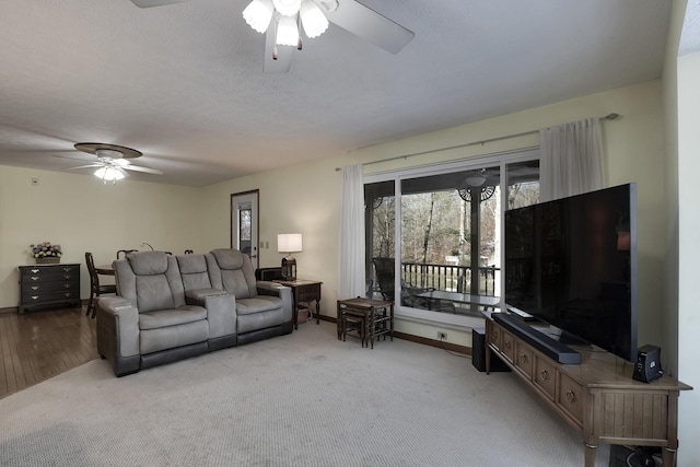 carpeted living room with a textured ceiling and ceiling fan