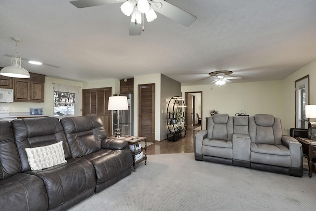 carpeted living room featuring ceiling fan