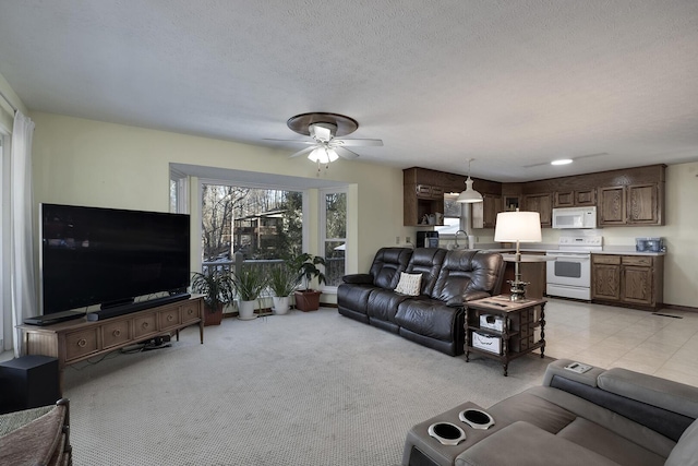 living room with light carpet, ceiling fan, sink, and a textured ceiling