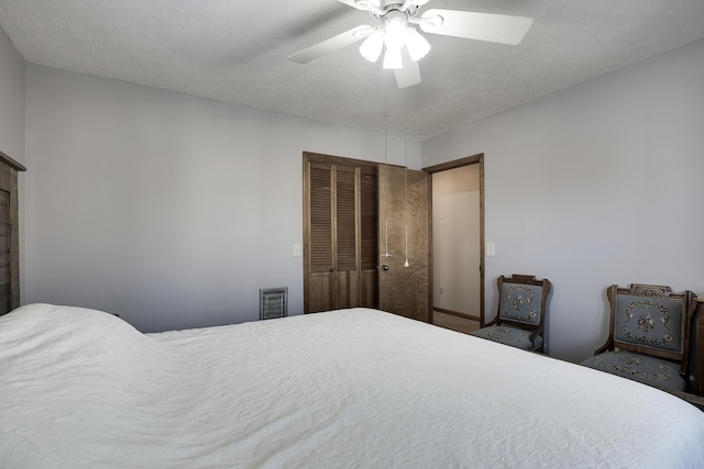 bedroom featuring a textured ceiling, ceiling fan, and a closet