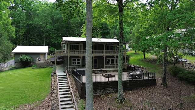 rear view of house with stairs, an outdoor fire pit, a deck, a patio, and a yard
