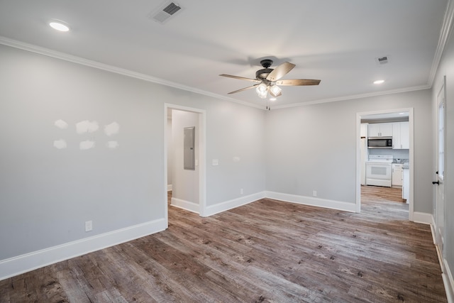 spare room with ceiling fan, wood-type flooring, ornamental molding, and electric panel