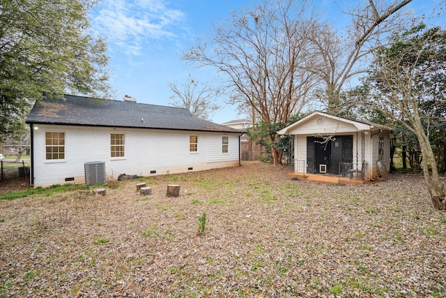 rear view of house with central AC and an outbuilding