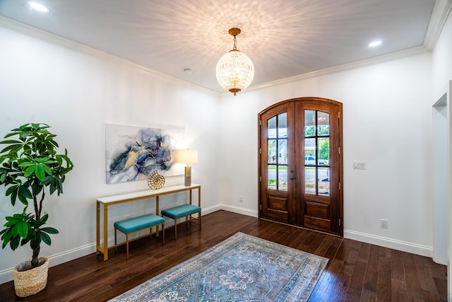 foyer with french doors, ornamental molding, dark hardwood / wood-style floors, and a notable chandelier